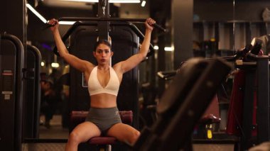 Aktif bir kadın spor salonunda güç ve forma odaklanmış bir şekilde son sürat hareket ediyor..