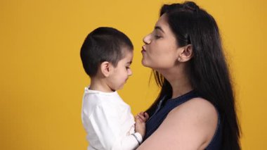 Bir anne çocuğuyla sevgi dolu bir kucaklaşmayı paylaşır, yakın bağlarını ve sevgisini gösterir..