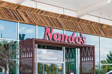 Kırmızı logolu ve camlı pencereli Nandos restoranının ön cephesi. Londra, İngiltere, 28 Temmuz 2024