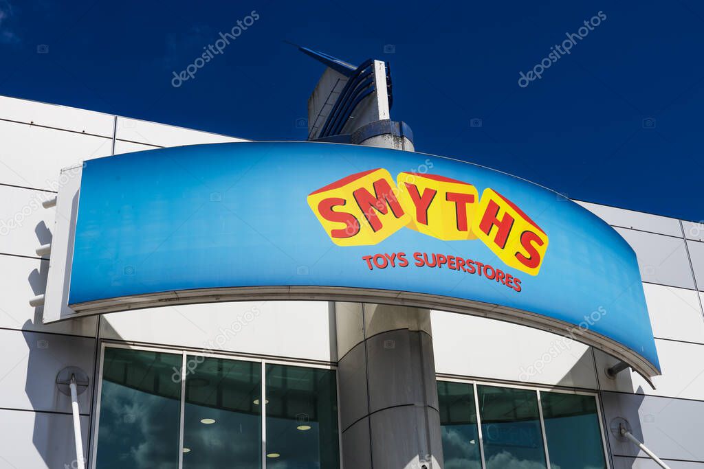 Smyths Toys Superstores logo on a curved storefront canopy under a bright blue sky. London, UK, 28 July 2024
