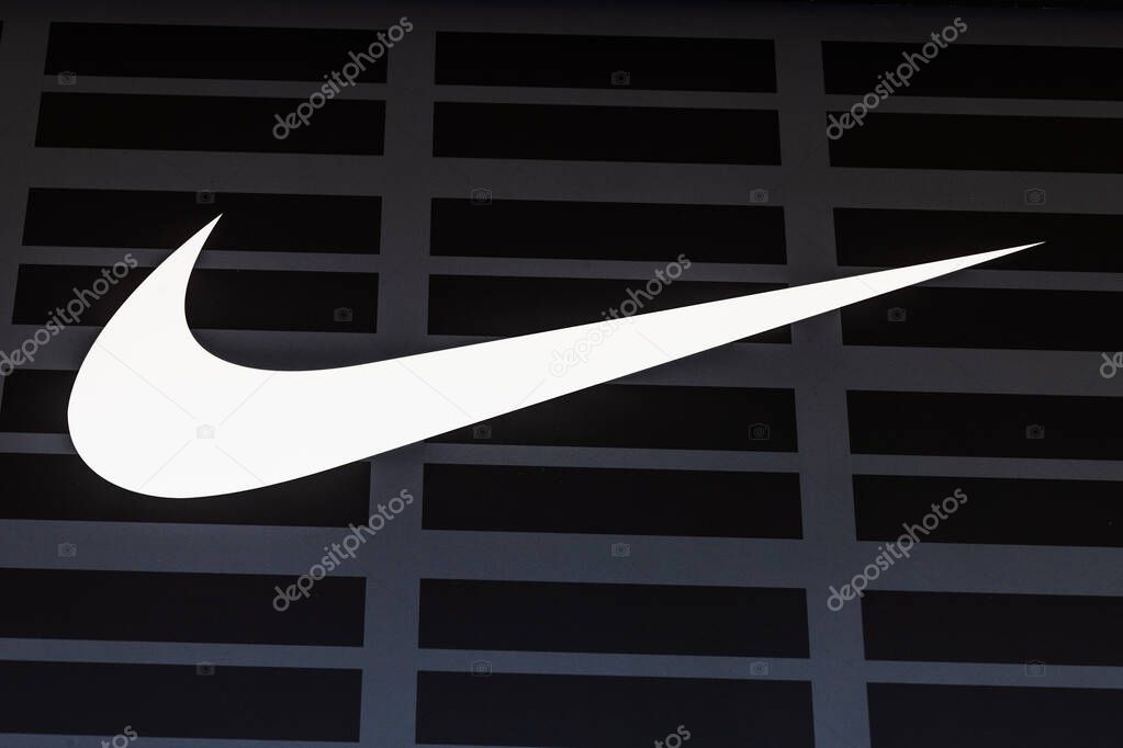 Close up of white Nike swoosh logo on dark shop facade. London, UK, 28 July 2024