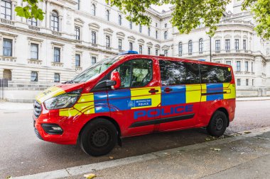 Sokakta belirgin kırmızı, sarı ve mavi işaretli bir Metropolitan Polis minibüsü. Londra, İngiltere, 10 Ağustos 2024