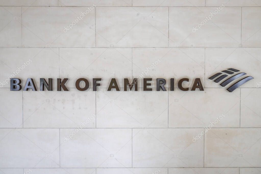 The Bank of America name and flag logo is displayed on an exterior stone wall of a corporate headquarters.