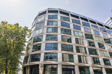 Londra 'daki modern eğimli cam ofis binası, gösterişli şehir mimarisi içeriyor.