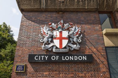 Londra şehrinin yakınlarında bir tuğla cephede silah ve işaret levhası var. Londra, İngiltere, 17 Ağustos 2024