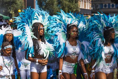 Londra 'daki Notting Hill Karnavalı' nda maskeli bir grup turkuaz tüylü kostüm giyiyor. Londra, İngiltere, 25 Ağustos 2024