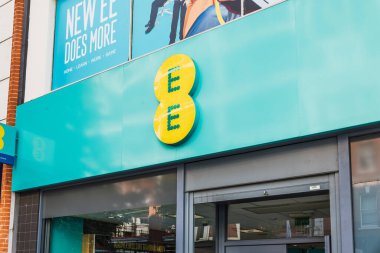 İngiltere 'nin ana caddesindeki EE perakende mağazasının önünde parlak logo işaretleri var. Londra, İngiltere, 5 Ekim 2024