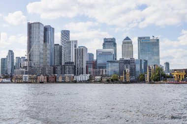 Canary Wharf, Londra 'nın modern panoraması. Thames Nehri' nin üzerinde yumuşak bulutların altında cam gökdelenler var. Londra, İngiltere, 5 Ekim 2024