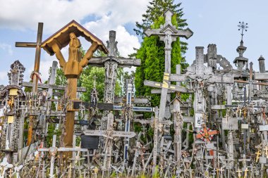 Litvanya Haç Tepesi 'nin çarpıcı manzarasında parlak bir gökyüzünün altında yüzlerce ahşap haç, tespih ve dini semboller sergileniyor. Siauliai, Litvanya, 19 Haziran 2025