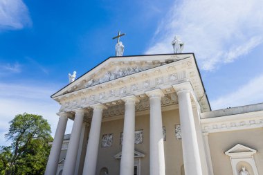 Vilnius Katedralleri 'nin alçak açılı görüntüsü neoklasik cephe uzun beyaz sütunlar, pedikür heykeller ve Litvanya' nın Vilnius Eski Kasabası 'ndaki parlak mavi gökyüzü..