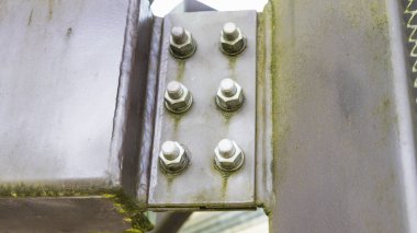 Sürgülü çelik kiriş bağlantısının makro görüntüsü. Geniş tabaka, altıgen fındık ve aşınma izleri gösteriyor..