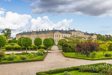 Letonya 'daki Rundale Sarayı ve Fransız tarzı bahçelerin panoramik manzarası. Zarif rokoko cephesi, peyzaj parkı ve turizm ve kültür için düzenli yollar..