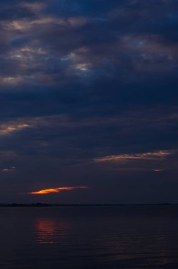 Sakinleştirici güneş ışınları ile doğal deniz mavisi arka plan. Beyaz bulutlu deniz ve gökyüzü. Kopya alanı, yaz tatili konsepti. gün batımı