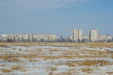  Kış sabahı manzarası karla kaplı bir tarla ve açık mavi gökyüzünün karşısındaki şehirlerde evler.