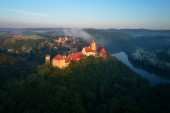 Letecký pohled na krásné, Moravský královský hrad Veveří nebo Burg Eichhorn, na skále nad vodní přehrady na řece Svratce. Velký hrad nad mlžným stromy v ranním světle. Letecká fotografie.