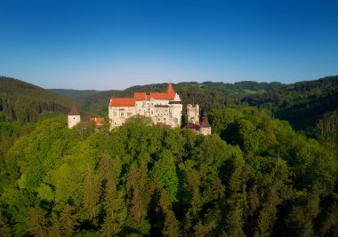 Moravyalı kale Pernstejn, bir tepe üzerinde Bohemian-Moravyalı Highlands mavi gökyüzü karşı derin ormanlar üzerinde duruyor. Hava fotoğrafçılığı. Çek peyzaj antik royal castle, Çek seyahat yer.