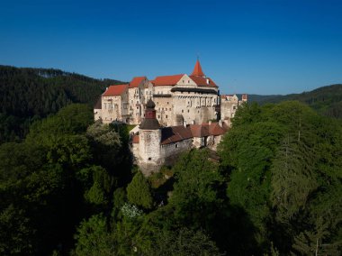 Moravyalı kale Pernstejn, bir tepe üzerinde Bohemian-Moravyalı Highlands mavi gökyüzü karşı derin ormanlar üzerinde duruyor. Hava fotoğrafçılığı. Çek peyzaj antik royal castle, Çek seyahat yer.