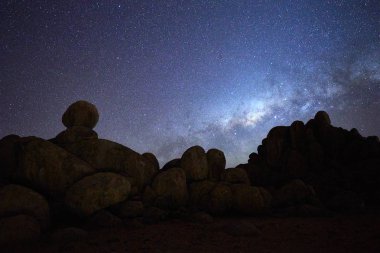 Samanyolu ve Afrika gökyüzü yıldız karşı yuvarlak kayalık yapılar silüeti. Gece gökyüzü fotoğraf. Twyfelfontein, Madisa, Damaraland, Namibya.