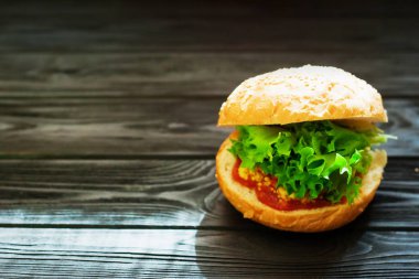 Et, salata, domates ve rustik vintage koyu ahşap zemin üzerine hardal dolu Burger yakın çekim