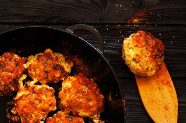 Koyu ahşap arka plan üzerinde bir tava içinde baharatlar köfteyle. Üstten görünüm. Kopya alanı.