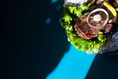 Lezzetli taze yayın balığı koyu turkuaz arka plan üzerinde. Balık aromatik otlar, baharatlar ve sebzeler - sağlıklı gıda, diyet veya pişirme kavramı ile