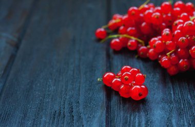 Koyu ahşap masa üzerinde kırmızı kuş üzümü