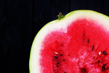 Koyu ahşap masa üzerinde taze dilimlenmiş karpuz