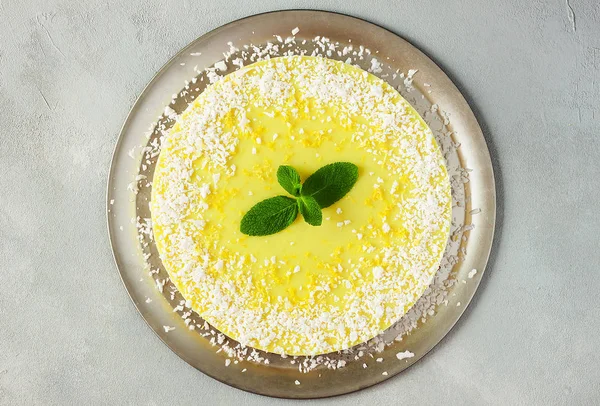 Healthy dessert - raw vegan lemon and coconut cake on grey background - gluten free, lactose free