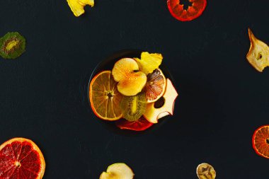 Meyve cips koyu arka plan üzerinde organik karışımı. Kuruyemiş - elma, muz, narenciye. Sağlıklı tatlı snack. Susuz ve çiğ yiyecek. Sağlıklı gıda comcept. Üstten Görünüm