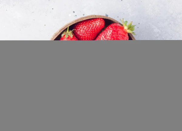 A bowl of fresh organic ripe strawberries with mint on grey stone background, top view. Healthy eating concept — Stock Photo, Image