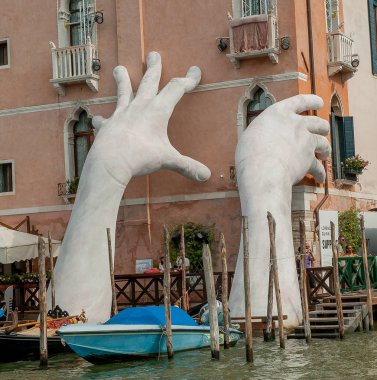 VENICE, ITALY - August 2017: Monumental hands rise from the water in Venice to highlight climate change clipart
