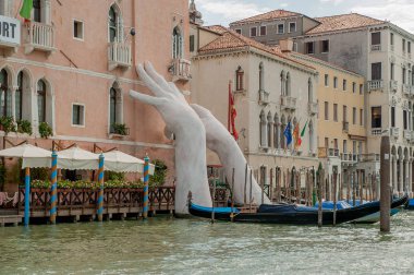 VENICE, ITALY - August 2017: Monumental hands rise from the water in Venice to highlight climate change clipart