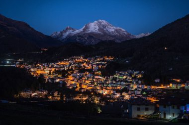 Serina mountain village illuminated at night clipart