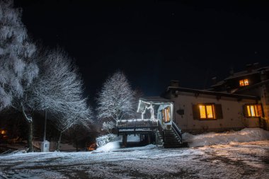Kar yağışı gün batımında sonra kulübe