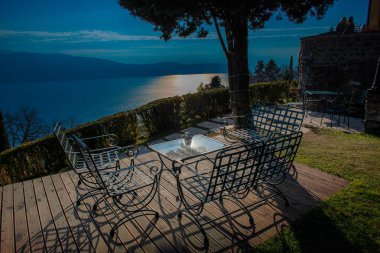 ile masa, sandalye ve şezlonglar göl manzaralı mobilyalı bahçe