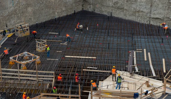 Trabajadores en el trabajo para la construcción de la base de hormigón armado — Foto de Stock