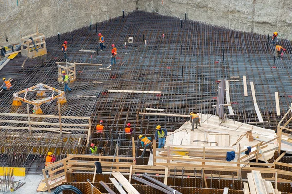 Trabajadores en el trabajo para la construcción de la base de hormigón armado — Foto de Stock