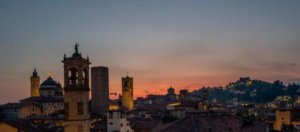 Bergamo bij zonsondergang in de oude stad met torens en klokkentoren, — Stockfoto