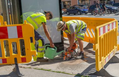 Innsbruck Avusturya 27 Temmuz 2020: Hortumla betonu kesen işçiler, tozu önlemek için bıçağı ıslatıyorlar