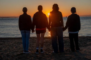 Şafakta bir grup arkadaş güneşin doğmasını bekliyor.