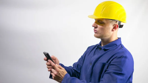 Construtor Olha Para Telefone Uma Mensagem Trabalhador Capacete Amarelo Sua — Fotografia de Stock