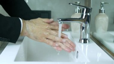 Elinizdeki kiri suyla yıkayın, yakın plan el yıkama, adam ellerini sıyırdı, temiz ve hijyenik tutuyor, böylece virüs bulaşmıyor.