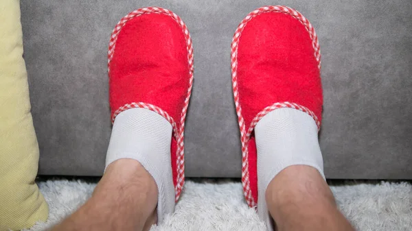 男人在家里放松 穿拖鞋的腿 室内温暖 脚踏在温暖的地毯上 — 图库照片
