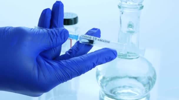 医療用手袋の医師は 医療用注射器 コロナウイルスに対するワクチン 実験室でのCovid 19に対するワクチンの開発 クローズアップ — ストック動画
