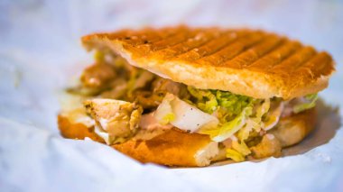 Sulu dener paketten çıktı, lezzetli hamburger, taze sebze ve tavuklu taze sosisli sandviç, yakın plan.