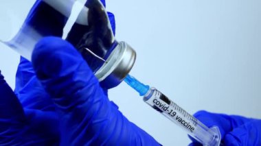 Şırıngada bir dizi aşı, koronavirüs hastalığının tedavisi, bir doktor CV19 için bir şırıngaya tedavi uyguluyor.