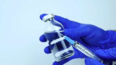 Coronavirus enfeksiyonu için bir kutu aşı şırıngası, bir doktor covid-19 için bir tedavi gösteriyor, yakın plan. Virüs için tıbbi tedavi