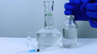 Bir ilaç, koronavirüs enfeksiyonuna karşı bir aşı, bir şişe aşıyı ele geçirmek için agresif.