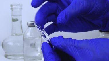 Doktor elinde bir ampul ve Coronavirus enfeksiyonuna karşı şırınga, kovid 19 'a karşı aşı, hastalık için ilaç, viral bir hastalık için ilaç, yakın çekim.