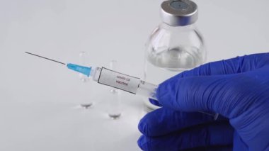  Bir şırıngada koronavirüs enfeksiyonuna karşı bir aşı, bir doktor kovid-19 için bir test ilacı gösteriyor, bir tıp çalışanının elinde viral bir salgın için bir tedavi, yakın plan